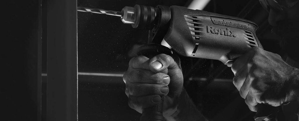 Een keurmeester meet met een testapparaat de aarding van een elektrisch handgereedschap